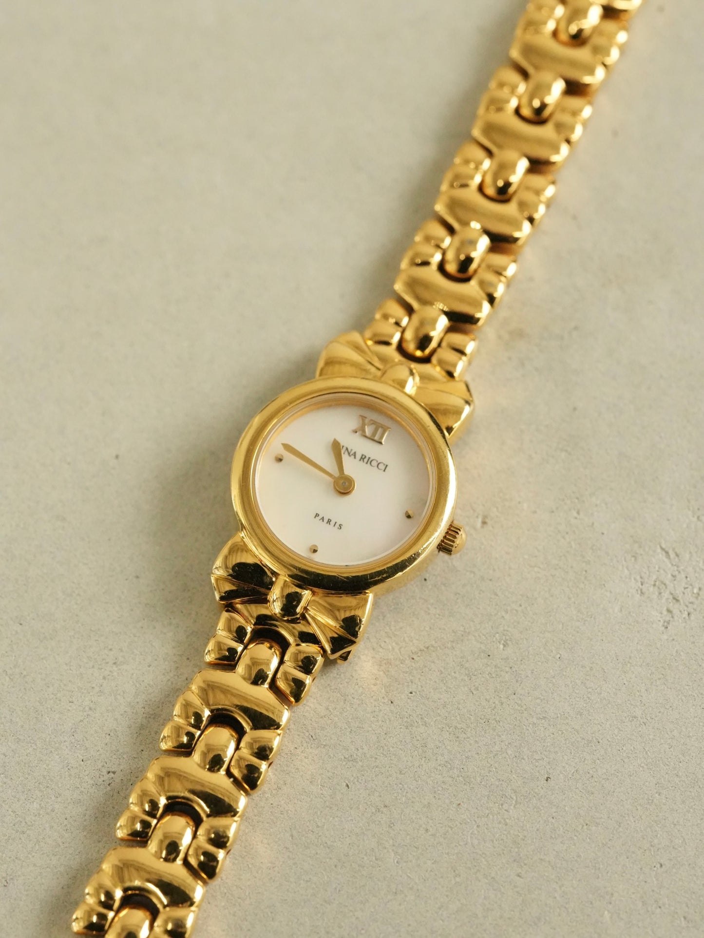 Nina Ricci Ribbon Motif Bracelet Watch – Gold Tone Mother of Pearl Dial – With Original Box & Extra Leather Straps Set