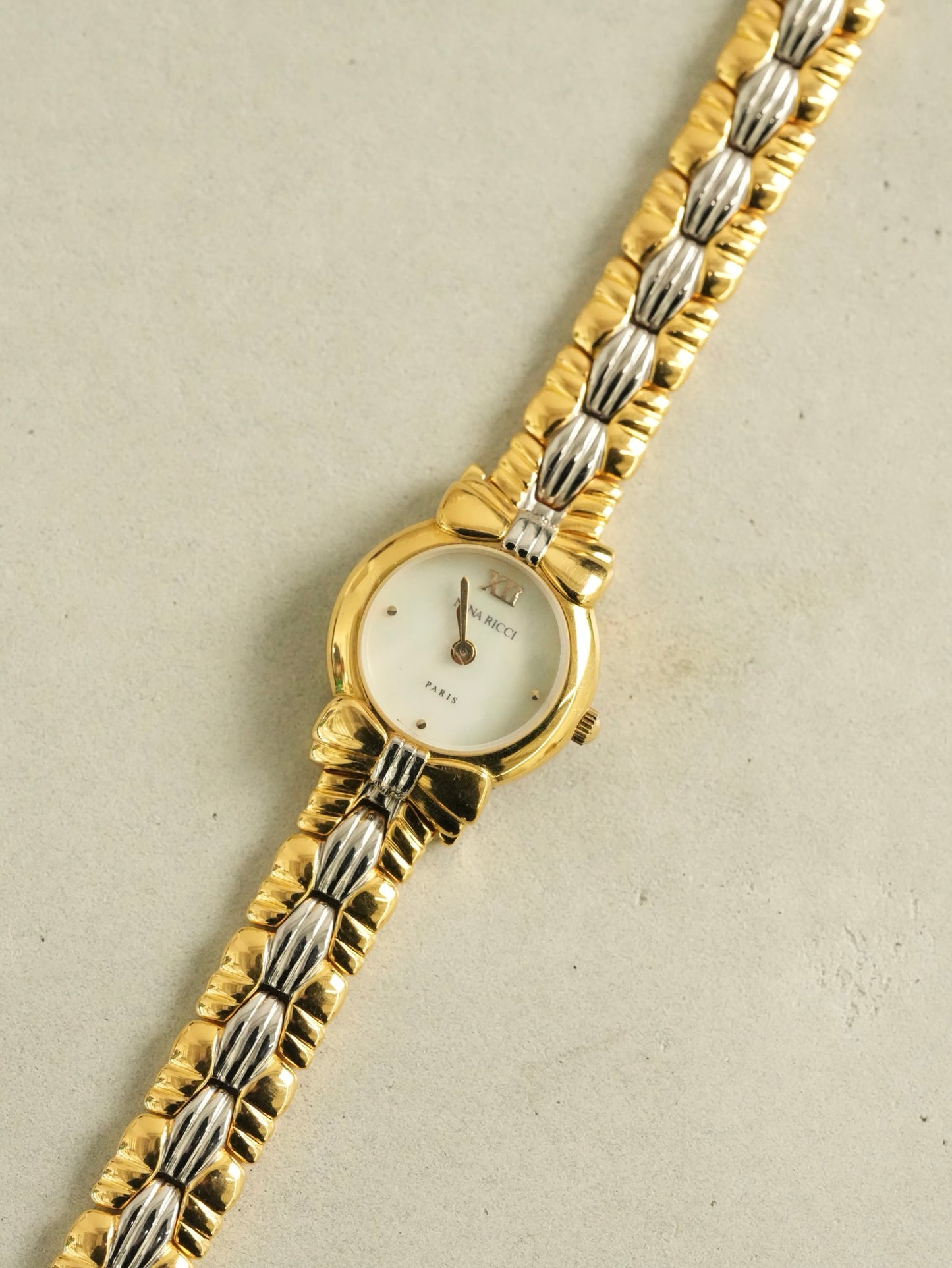 Nina Ricci Mother of Pearl Dial Two-Tone Bracelet Watch – Gold & Silver Belt Design